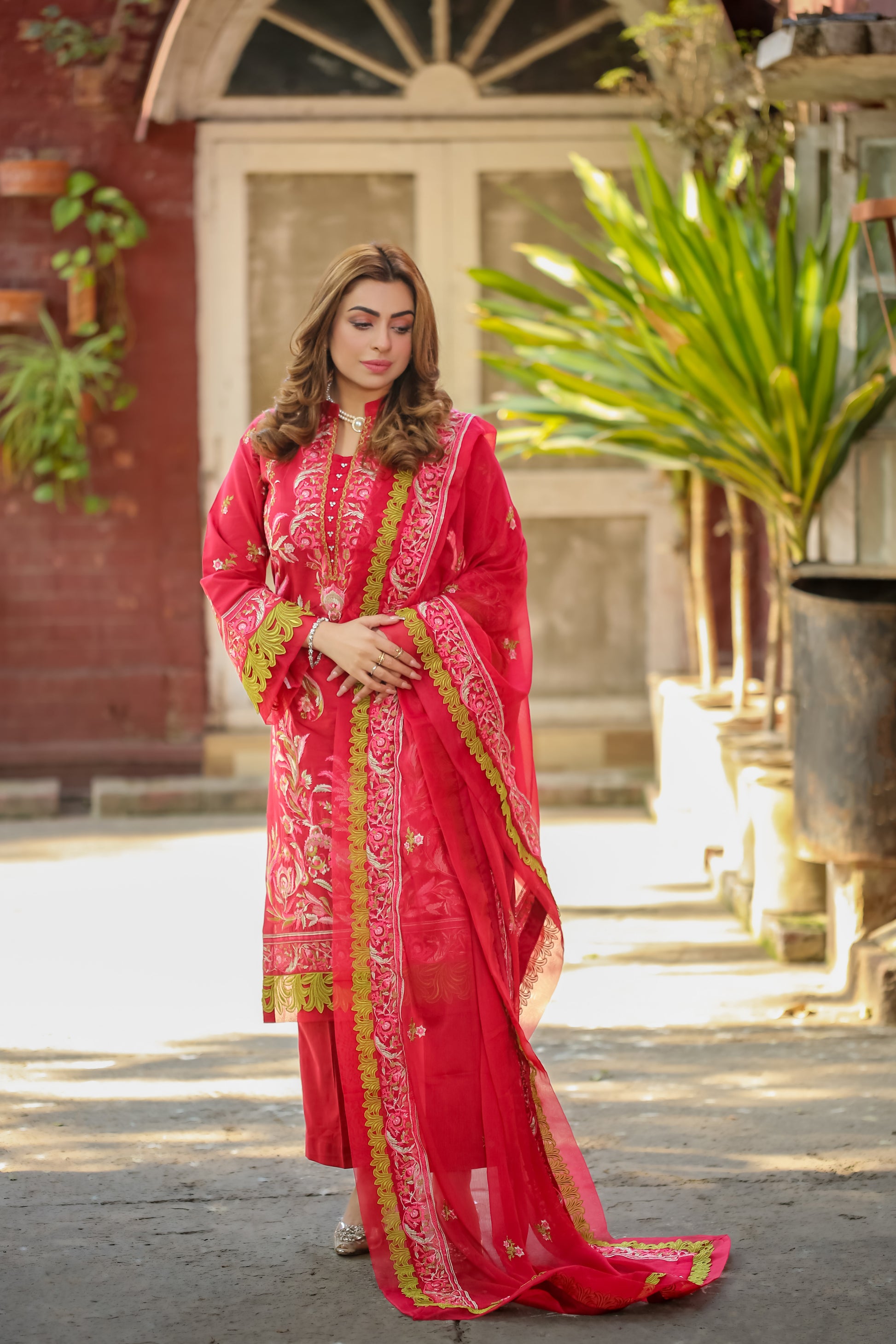 Elegant woman wearing Saadia Ahmed LWSU-25FE306 Embroidered Lawn in vibrant red with intricate designs